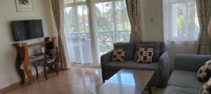 a living room with a couch and a glass table at Blue Water Resort in Diani Beach
