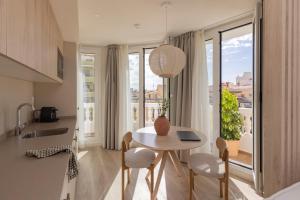 a small kitchen with a table and chairs and a window at Líbere Alicante Rambla in Alicante +82 photos