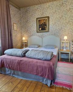 a bedroom with a bed with two pillows on it at STF Glasbruket Hostel & Apartments in Borensberg
