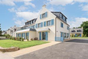 a large white house with blue windows at Le Logis du Manoir in Sarzeau