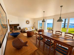 a living room with a wooden table and chairs at La Bretonne vue mer in Lanmodez