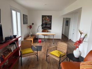 a living room with two chairs and a table at La Bretonne vue mer in Lanmodez +46 photos
