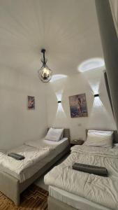 two beds in a room with a chandelier at Antika Hotel in Dahab +16 photos