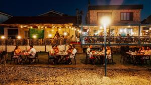 a group of people sitting at tables at night at Arz'Urla Restaurant & Otel in Urla