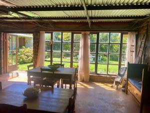 a living room with a table and a large window at Warbler's Haven in Wakkerstroom