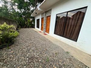 a house with a gravel driveway next to a building at Sapayag Backpacker's Inn in Dipolog