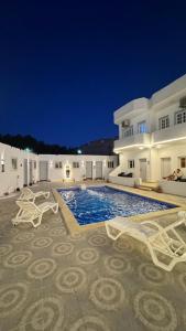a villa with a swimming pool at night at Antika Hotel in Dahab