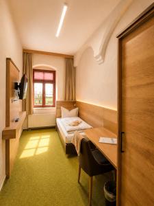 a hotel room with a bed and a desk at Pension am Markt in Wurzen