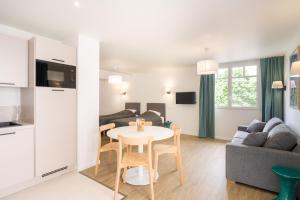 a kitchen and living room with a table and a couch at Le Logis du Manoir in Sarzeau