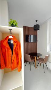 an orange jacket hanging on a wall next to a table at ЖК АЯ Студія 1 плюс 1 in Kropyvnytskyi