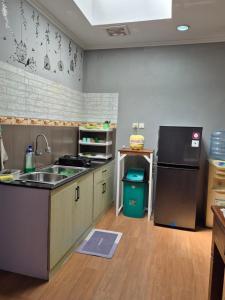 a kitchen with a sink and a refrigerator at Maninjau House in Jakarta