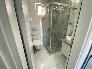 a bathroom with a shower and a toilet and a sink at Bodrum Nuran Boutique Apart in Bodrum City +11 photos
