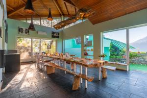 a large dining room with a large wooden table at Seclude Ramgarh Cliff's edge in Rāmgarh
