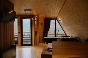 a living room with a tub and a large window at Golden Star Cottage in Kazbegi