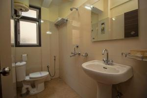a bathroom with a sink and a toilet at Hotel O Kshounish Residency in Mālda +21 photos