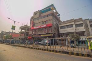 a row of buildings on a street with a fence at Hotel O Kshounish Residency in Mālda