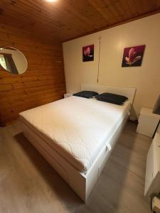 a bedroom with a white bed in a wooden room at chalet 282 - La Boverie in Rendeux +10 photos