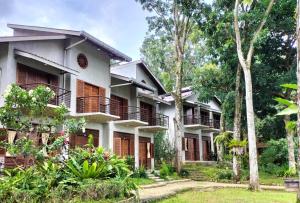 an exterior view of a resort with trees at Bukit Lawang Lodge in Bukit Lawang