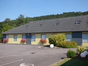 ein gelb-blaues Gebäude mit einem Parkplatz in der Unterkunft Hotel Premium in Forbach