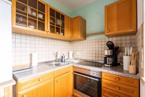 a kitchen with wooden cabinets and a sink at Appartement Bergluft in Sasbachwalden