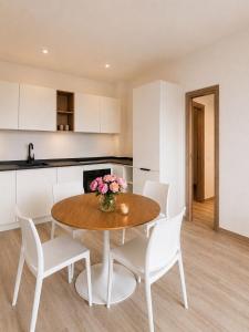 a kitchen and a table with white chairs and a table at Lake View Apartament 39 - Free Parking & Terrace in Cadegliano Viconago