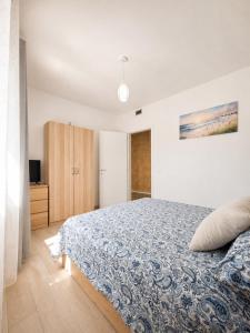 a bedroom with a bed with a blue comforter at A due passi dal mare in Giulianova