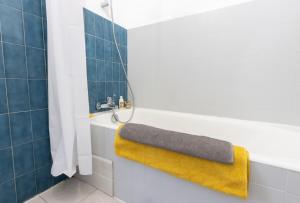 a bathroom with a yellow towel on a bath tub at "U Valincu" – Studio Centre Plage | by Efficios in Propriano