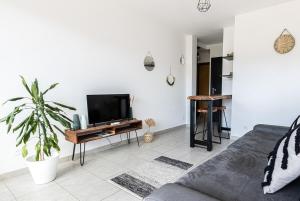 a living room with a couch and a tv at "U Valincu" – Studio Centre Plage | by Efficios in Propriano