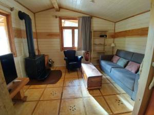 a living room with a blue couch and a wood stove at Masía El Moli de Can Aulet in Arbúcies