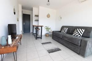 a living room with a couch and a tv at "U Valincu" – Studio Centre Plage | by Efficios in Propriano