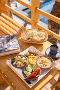 a table with plates of food and a basket of food at Amun Dahab Hotel in Dahab