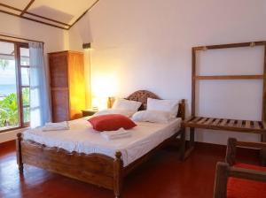 a bedroom with a bed and a window with the ocean at Bliss Bay Beach Resort & Spa in Nilaveli