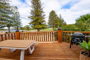 a grill and a picnic table on a wooden deck at Esperance Foreshore Apartments in Esperance