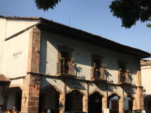 a building with potted plants on the balconies at Hotel Mansion Iturbe in Pátzcuaro