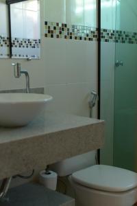 uma casa de banho com um lavatório, um WC e um espelho. em Pousada Paraíso de Itaúna em Saquarema