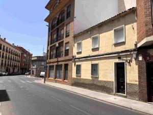 an empty street next to an old brick building at Apartamentos Cañada Sierra 23 in Talavera de la Reina