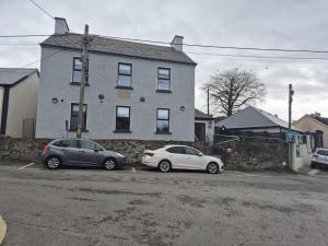 two cars parked in a parking lot in front of a house at The Old Schoolhouse River View in Donegal
