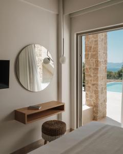 a bedroom with a mirror and a bed and a window at Tomas Villas in Paleros +56 photos