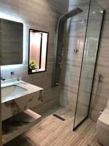 a bathroom with a shower and a sink and a mirror at شقق ازار المخدومه in Medina