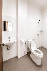 a white bathroom with a toilet and a sink at Rays Residence in Jakarta +18 photos