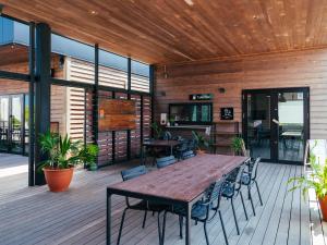 a wooden deck with a wooden table and chairs at ＨＯＴＥＬ ＬＯＣＡＬ ＢＡＳＥ＜宮古島＞ in Miyako-jima