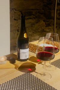 a bottle of wine and two glasses on a table at Cozy House with Douro View in Lamego +14 photos