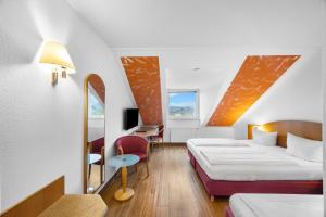 ein Hotelzimmer mit zwei Betten und einem Schreibtisch in der Unterkunft Hotel SunParc - SHUTTLE zum Europa-Park Rust 4km & Rulantica 2km in Ringsheim + 55 Fotos