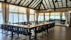 a large table and chairs in a room with windows at Spaces Bali Unique Boutique Hotel in Canggu