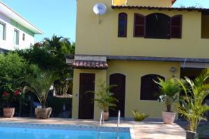 a house with a swimming pool in front of it at Pousada Paraíso de Itaúna in Saquarema