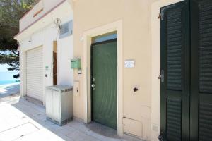 a green door on the side of a building at La Terrazza sul Mare - Sa Murta Apartments in Torre Grande