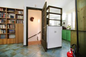 a kitchen with a refrigerator in a room with bookshelves at La Terrazza sul Mare - Sa Murta Apartments in Torre Grande +44 photos
