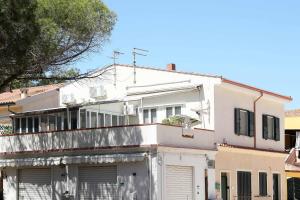 an old white building in a city at La Terrazza sul Mare - Sa Murta Apartments in Torre Grande