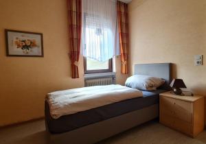 a small bedroom with a bed and a window at Moselbrücke - Serviced Apartments in Wincheringen