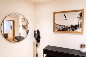 a bathroom with a mirror and a black vanity at Terra Alpina in Arosa +6 photos